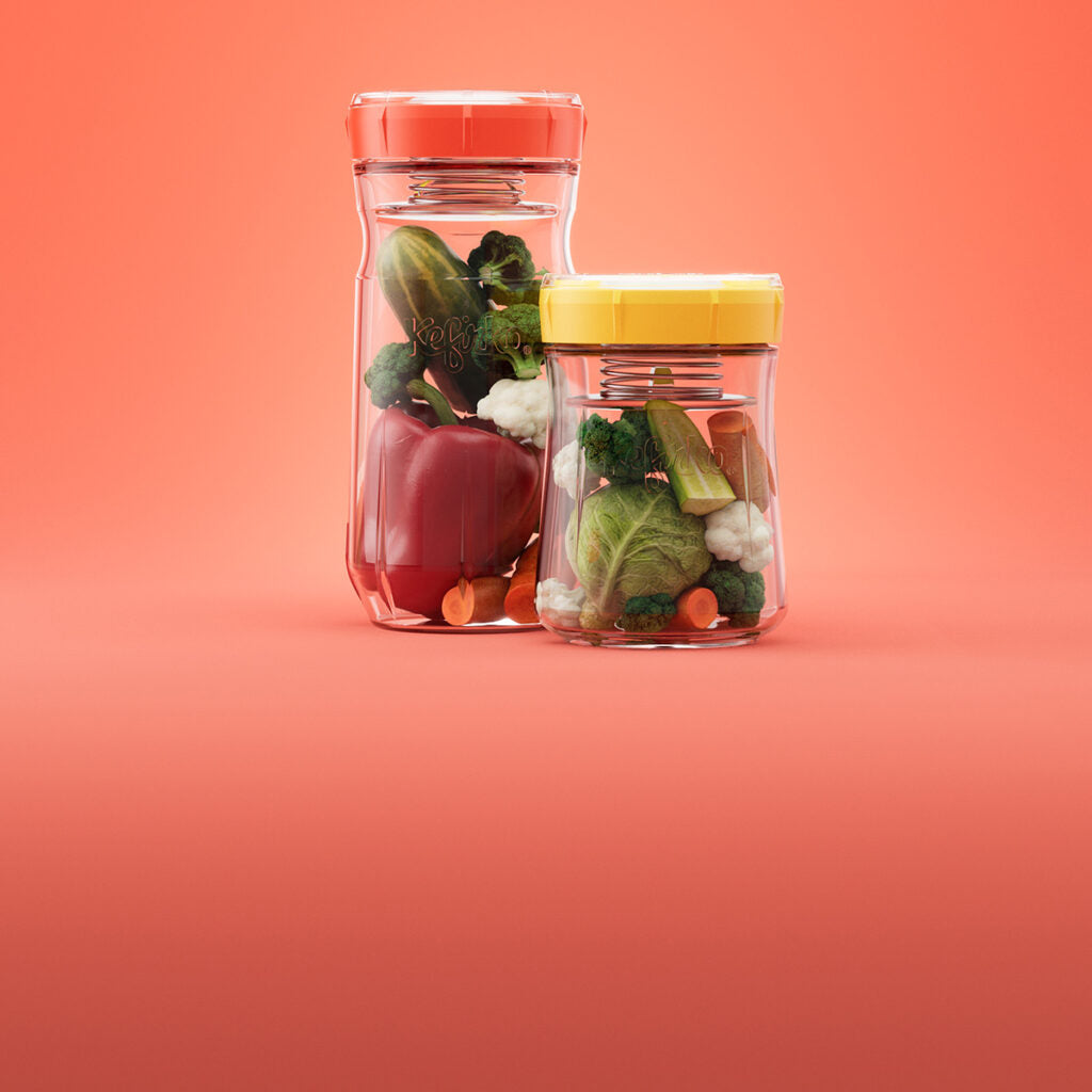 Dos frascos transparentes del fermentador de verduras de Kefirko están llenos de verduras frescas, como pimientos rojos, lechuga, zanahorias y brócoli, colocados sobre un fondo naranja. Adecuado para aquellos interesados en la fermentación de verduras.