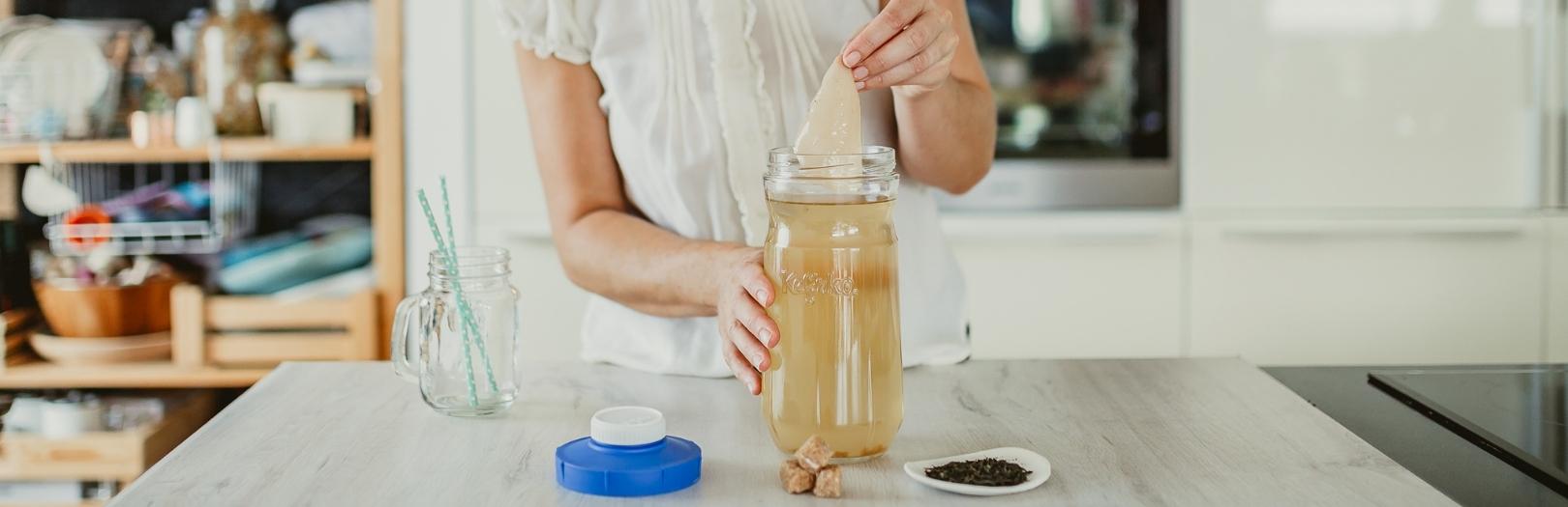 tarro de cristal con persona sacando el scooby de komucha16569323614d010d7d-0