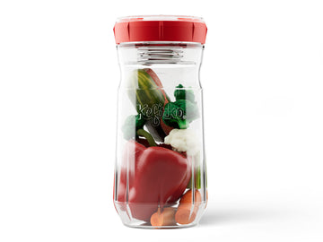 Fermentador de verduras Kefirko con tapa roja, lleno de pimiento, brócoli y zanahoria listos para fermentar.