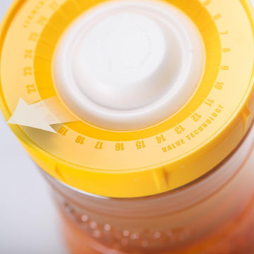 Primer plano de la tapa amarilla de un tarro de fermentación con contador de días y tecnología de válvula.