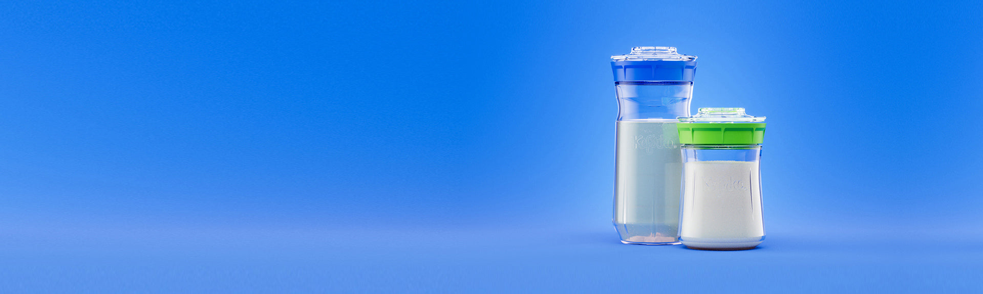 Dos fermentadores de vidrio Kefirko: uno con kéfir de agua y tapa verde, y otro con kéfir de leche y tapa azul.