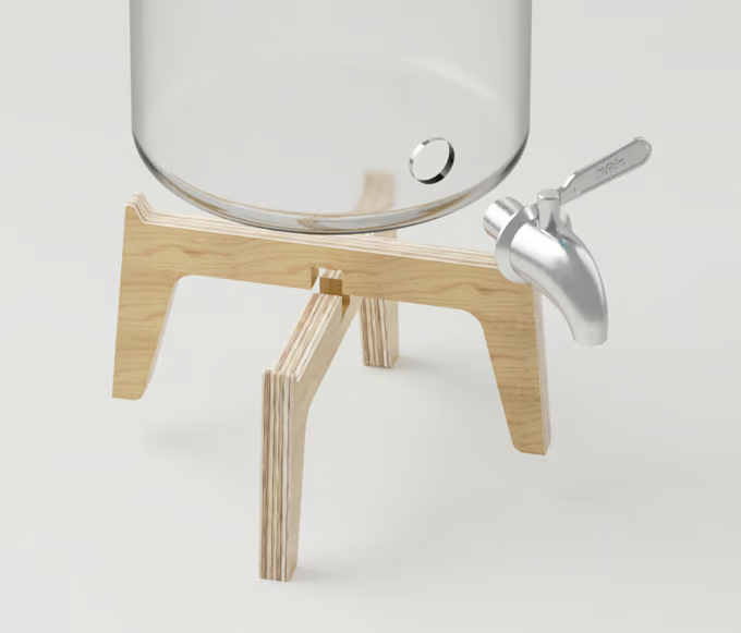 Detalle de la base de un tarro de vidrio para un kit kombucha, con su soporte de madera y el grifo de acero desmontado.