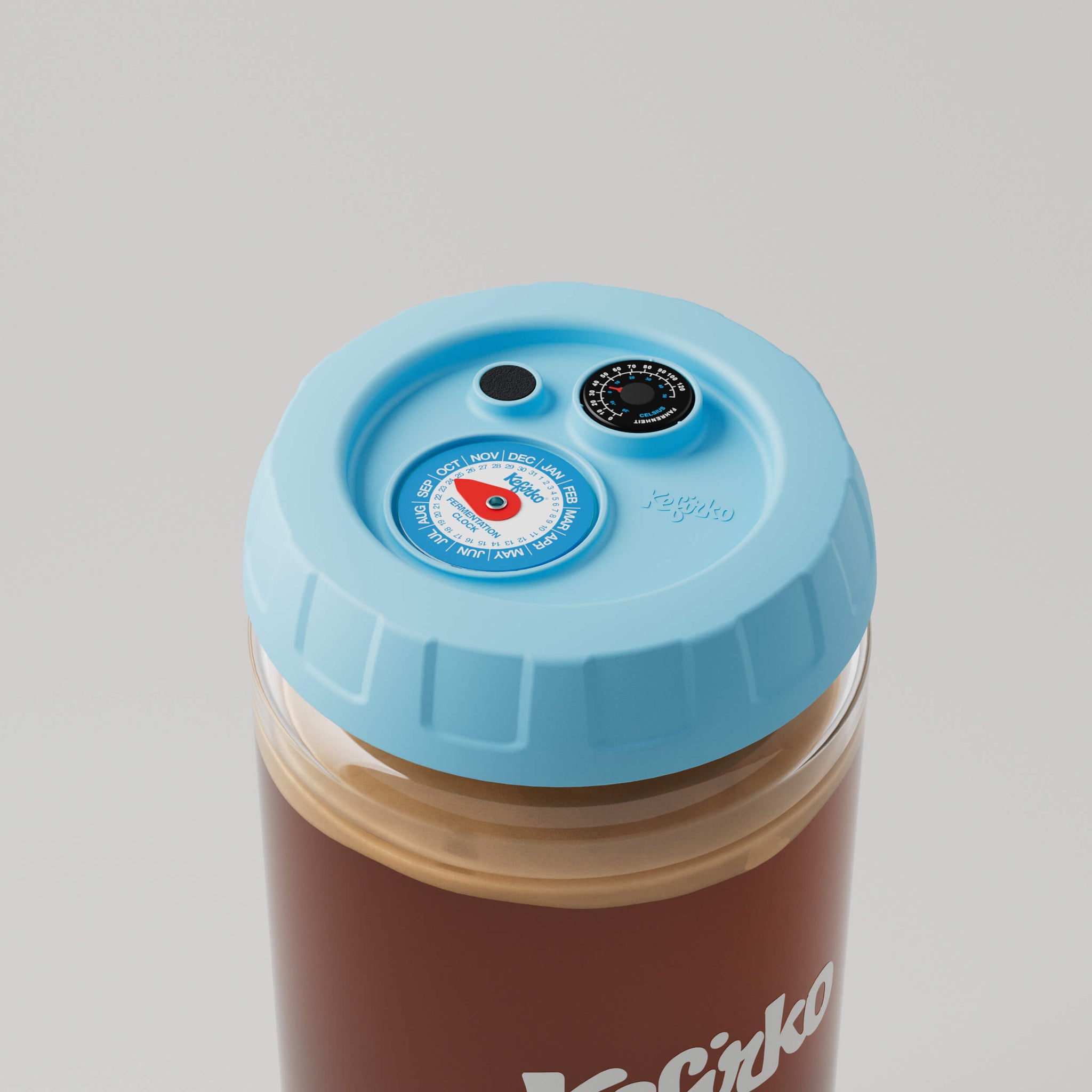 Vista superior del tarro de vidrio Kefirko con tapa azul que incluye un reloj de fermentación y un termómetro.