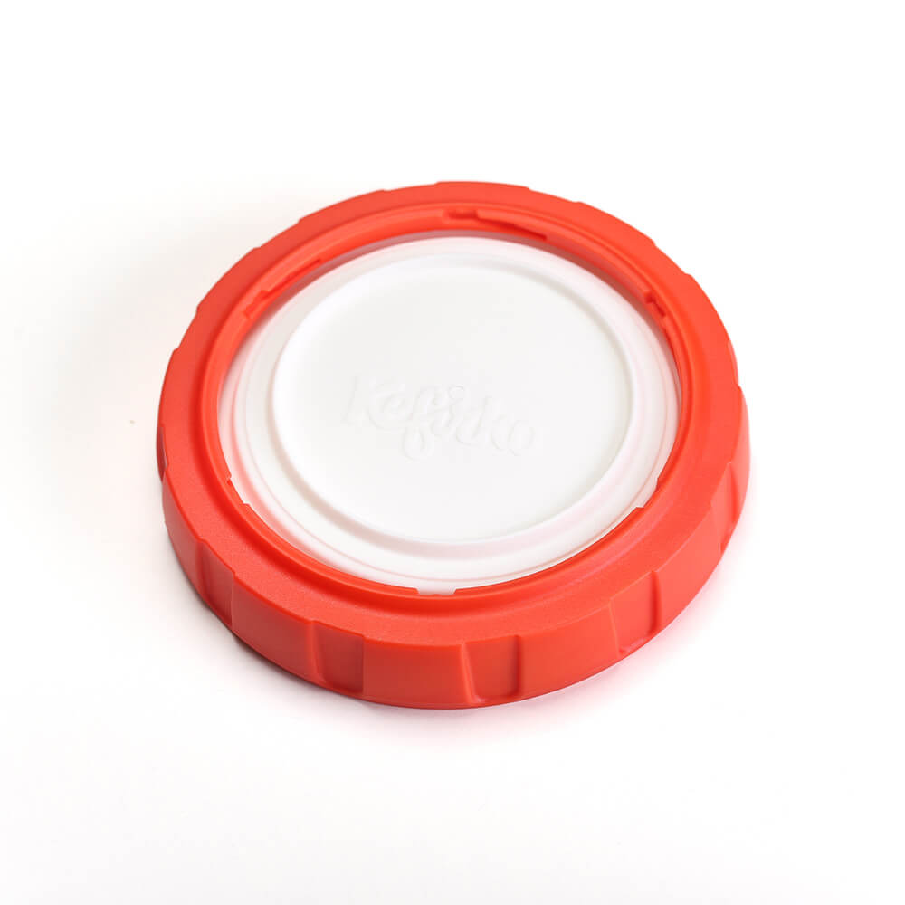 Tapa roja y blanca del kit masa madre con la marca Kefirko grabada en el centro sobre un fondo blanco.