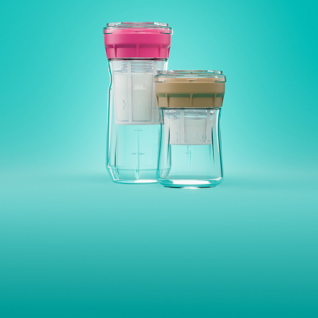 Sobre un fondo turquesa vibrante se presentan dos recipientes transparentes de la colección Cheesemaker de Kefirko. Los recipientes cuentan con tapas de colores, una en rosa y la otra en beige.