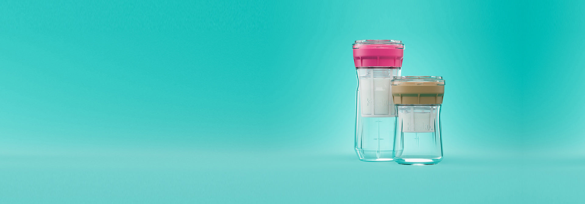 Dos fermentadores de queso de vidrio con tapa rosa y beige sobre un fondo turquesa, para hacer queso en casa.