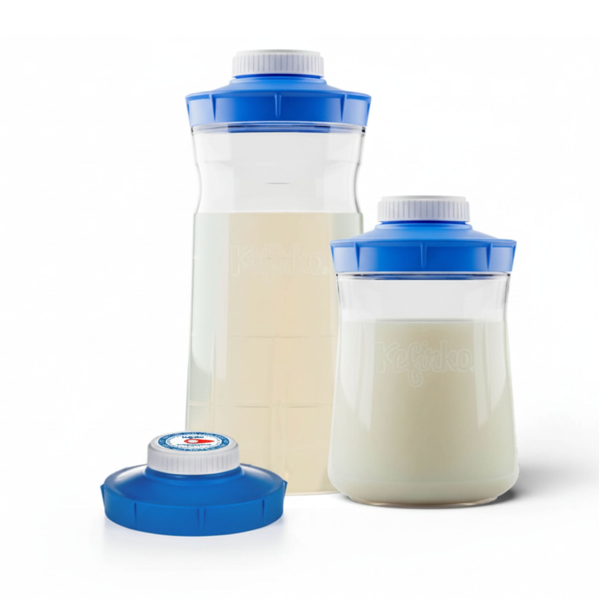 Dos tarros de vidrio Kefirko con kéfir de leche y agua, junto a la tapa con reloj de fermentación.