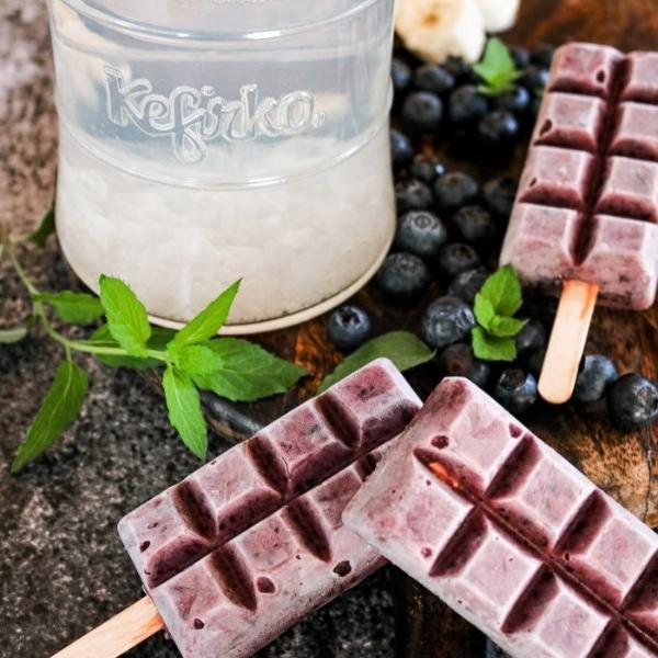tres polos de arandanos junto a bote con kefir de agua