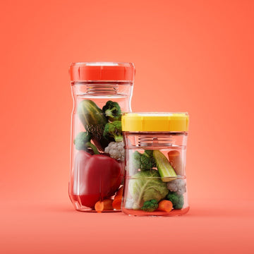 dos tarros de cristal con tapa roja y azul con verduras fermentando