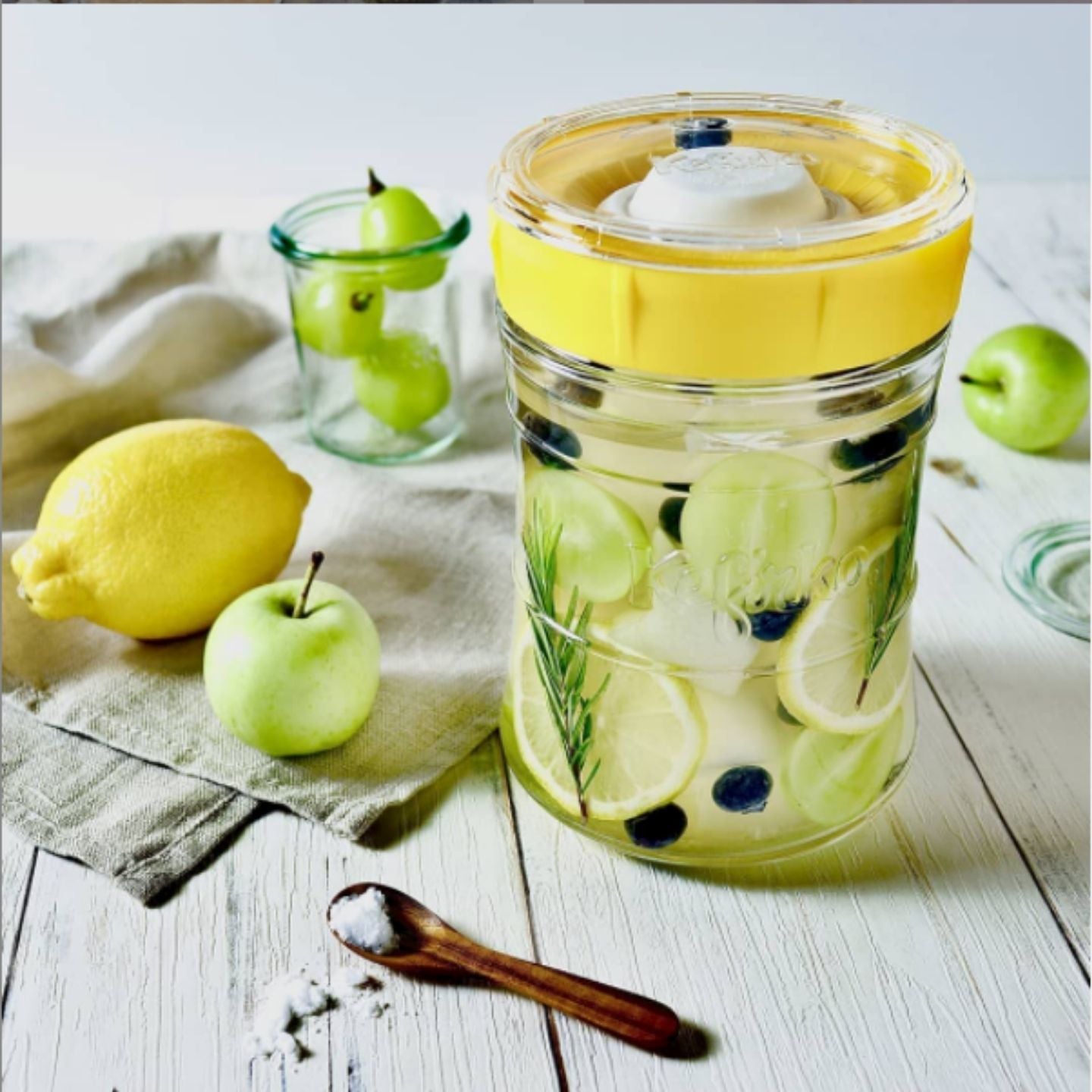 tarro de cristal fermentando agua limon y trozos de manzana